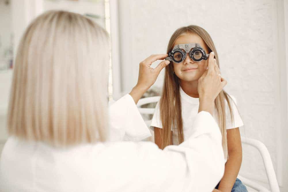 child eye test eye exam little girl having eye check up with phoropter doctor performs eye test child