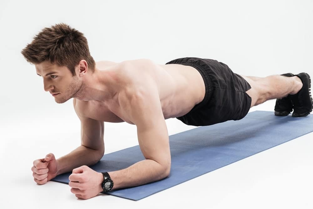 young sportsman doing plank exercise fitness mat2 min